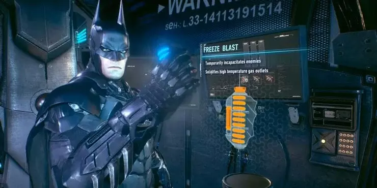 Batman holding a blue gadget