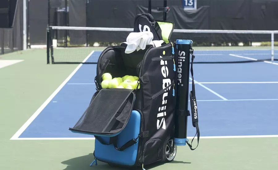 Slinger Bag placed on a hard court blue tennis court