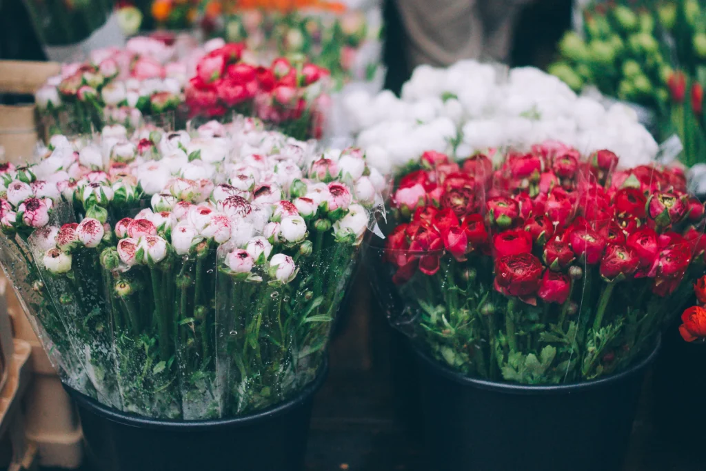 Pink and red flowers aranged in buckets, ready for selling