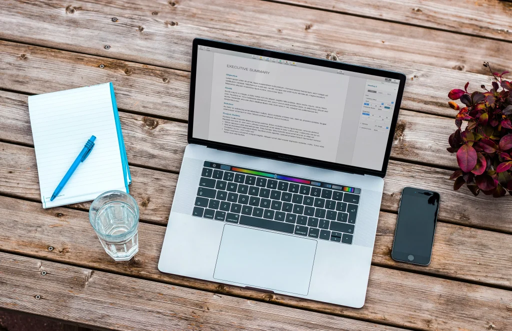 Laptop and mobile phone net to a notebook and a glass of water