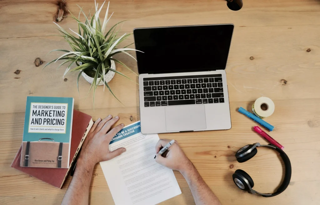 Helicopter view of a table on which are a laptop headphones and books