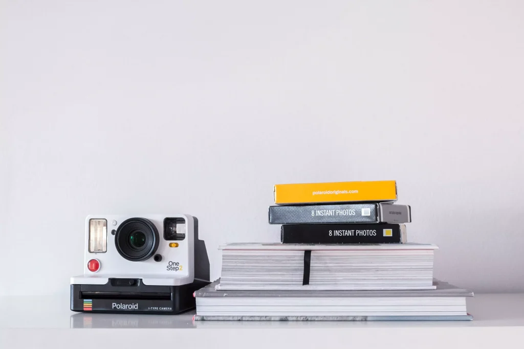 The Polaroid Go Camera next to films and albums