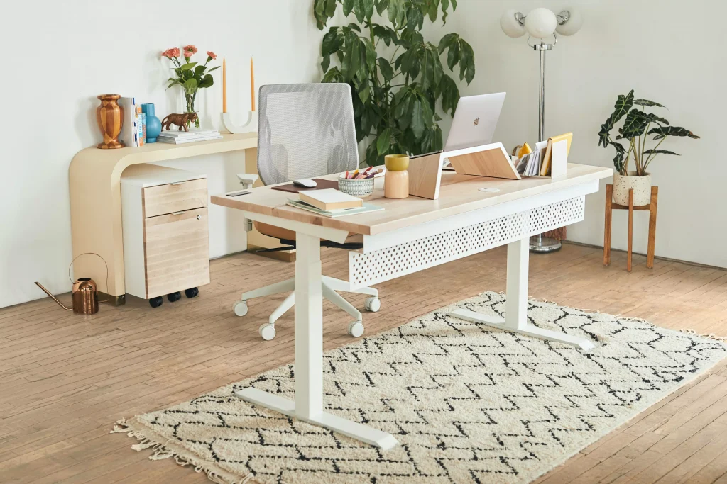 A very nicely designed office with an adjustable desk and a white ergonomic chair