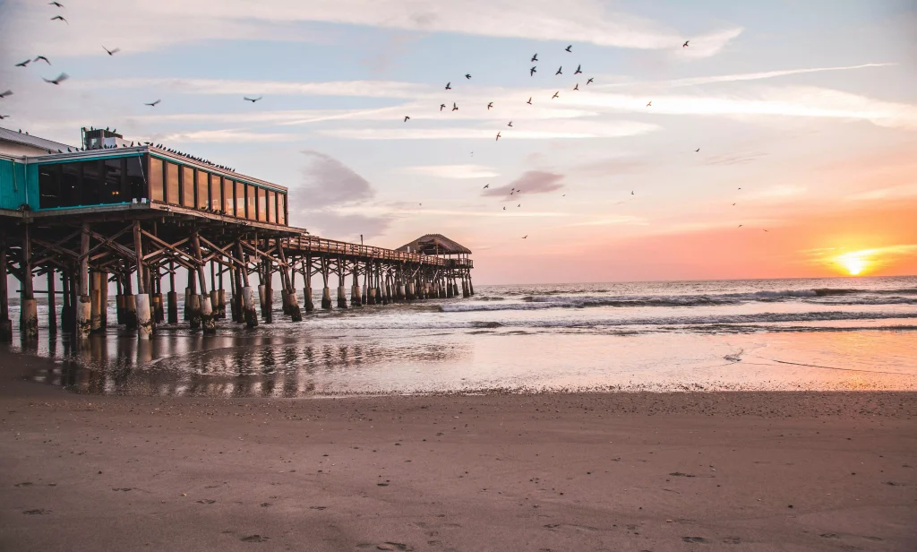 Sunset on a beach with a dock