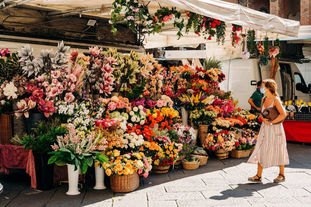 Women with mask on looking at a flowers shop display of flowers