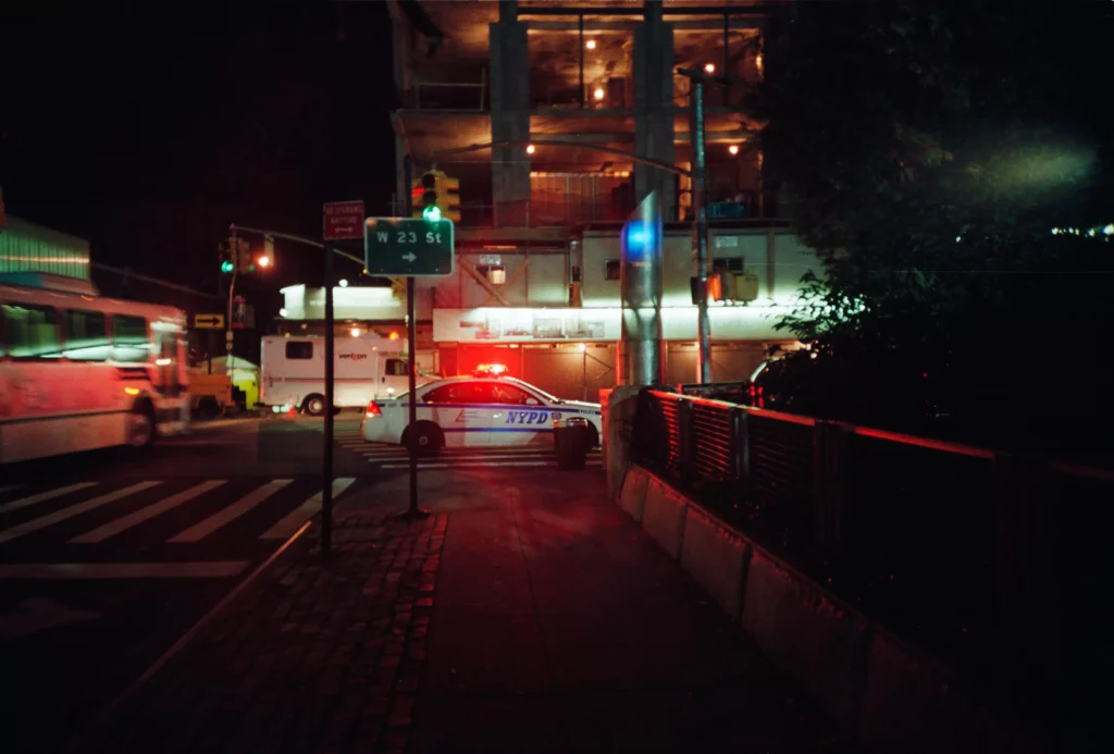 Street in a city, where in the background there is a police car with the police lights on