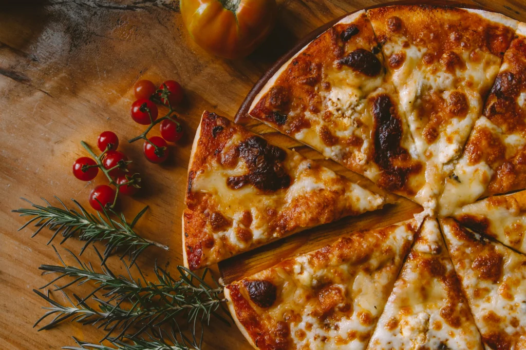 Pizza with sweet tomatoes next to it