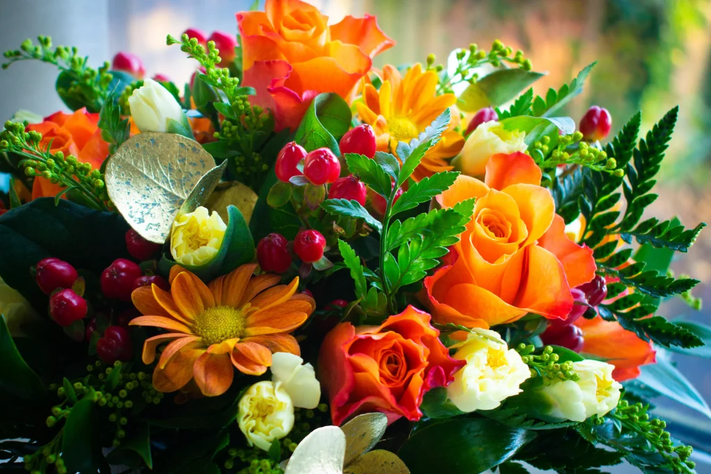 A buqeut of flowers whicha are orange red and yellow