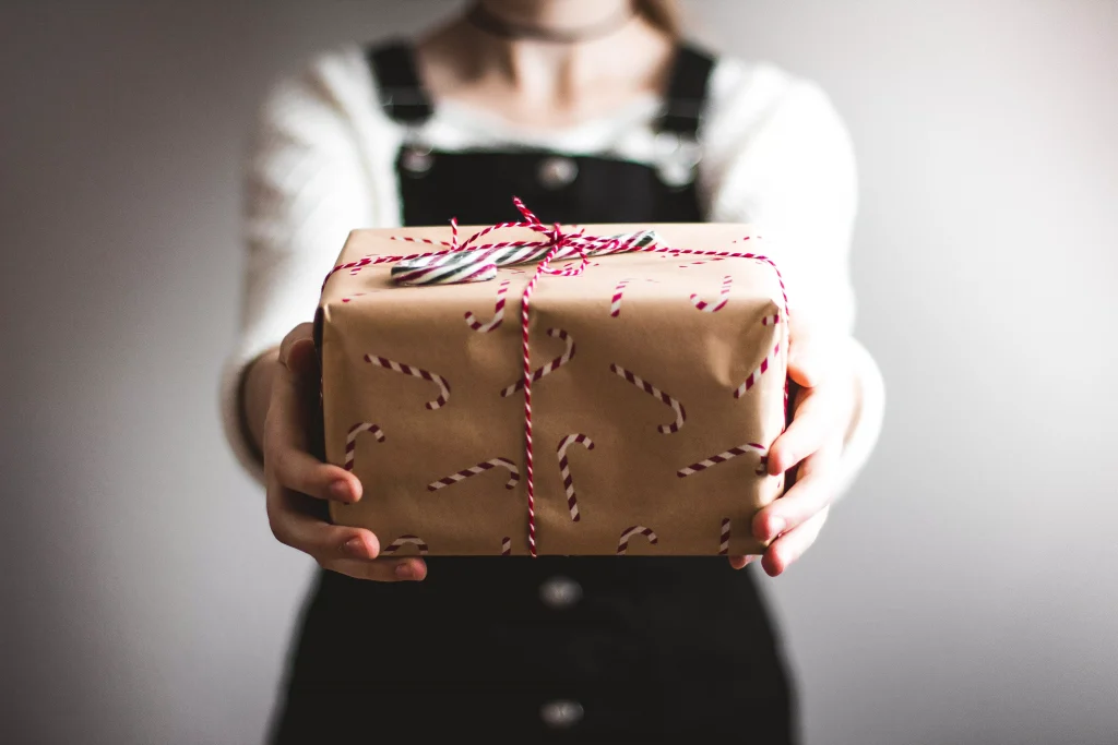 A nicely wrapped gift which is held by a women