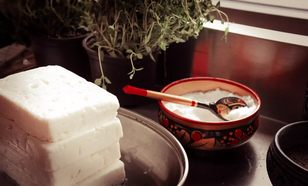 Cut in squares cottage cheese next to a bowl of cottage cheese.