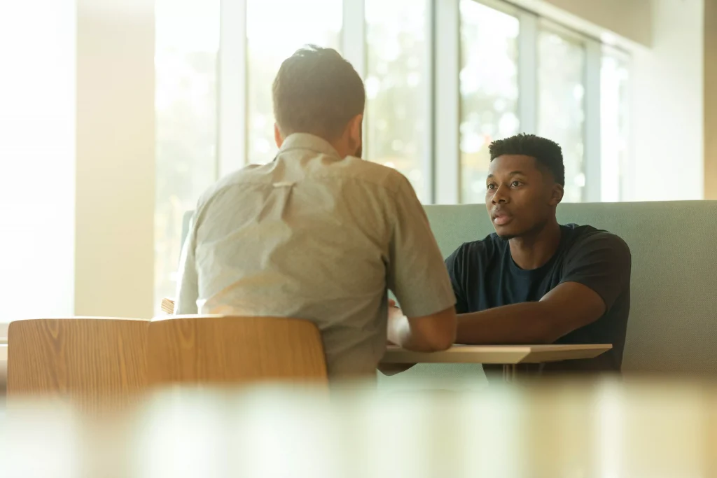 Two succesfull gentleman siting at a table and talking