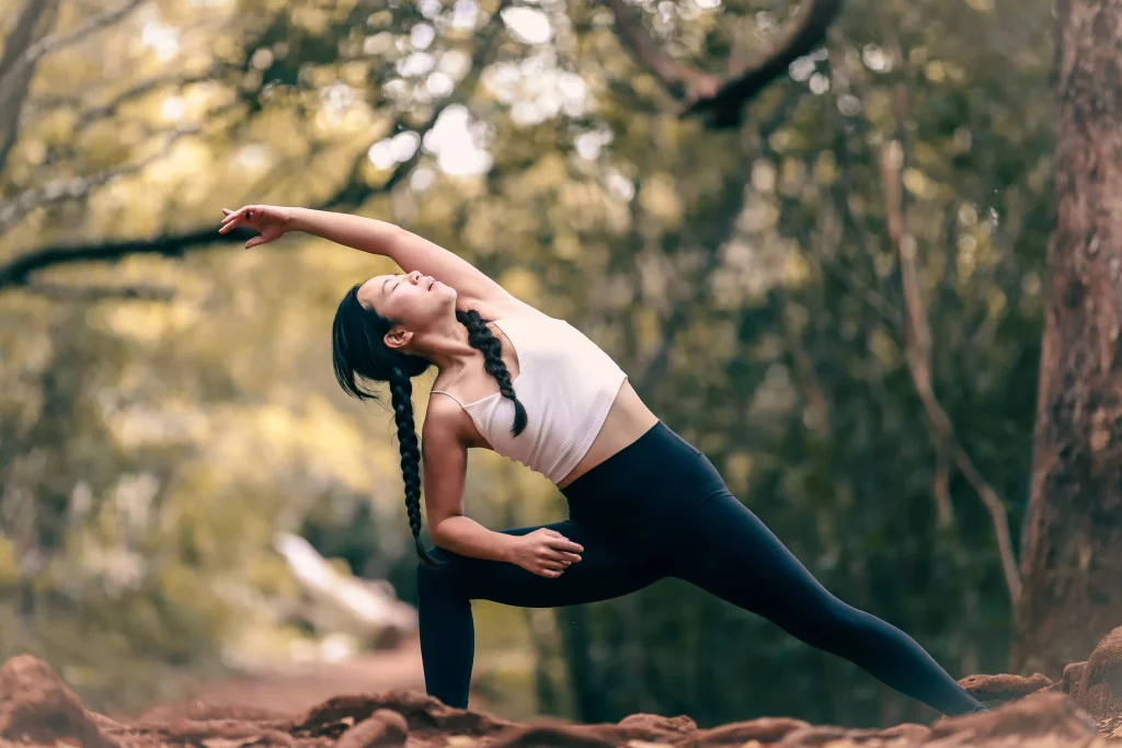 Girl with pink top and yoga pants stretching