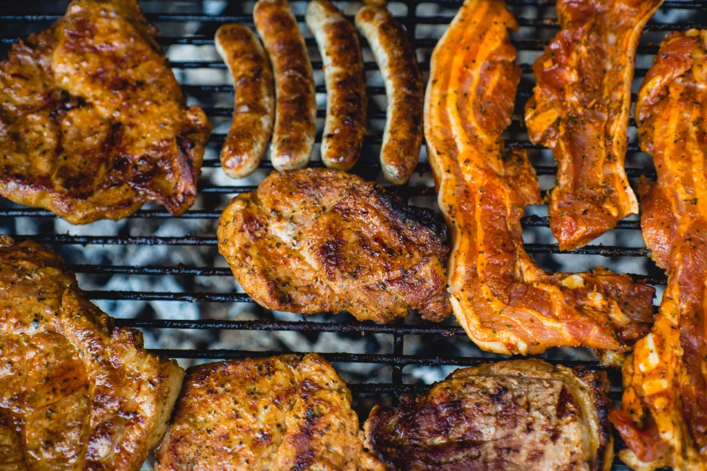 Lean beef, sausages and chicken on grill, prepared to eat.