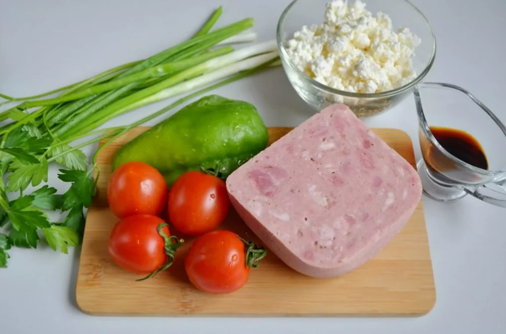 A lean meat with tomatoes and greensalad next to a sauce and yoghurt