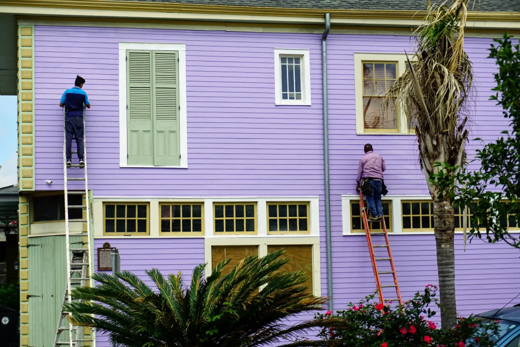 2 man paining a house in purple