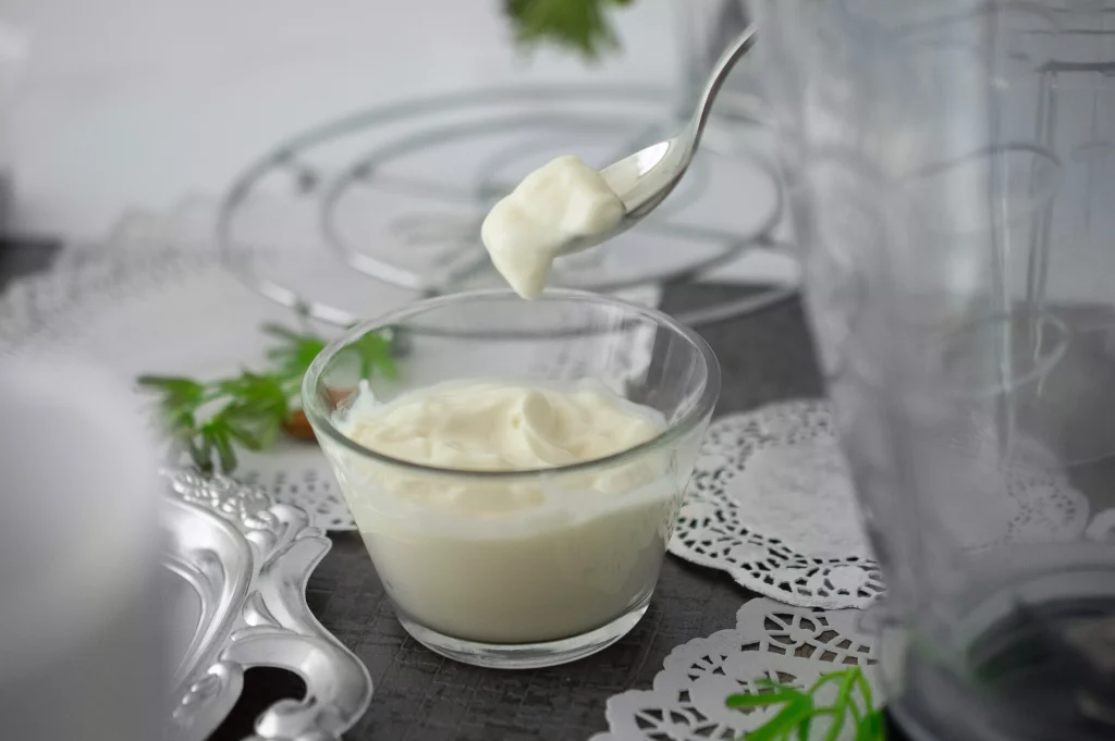 Fresh Yoguhrt in a bowl picked up with a spoon