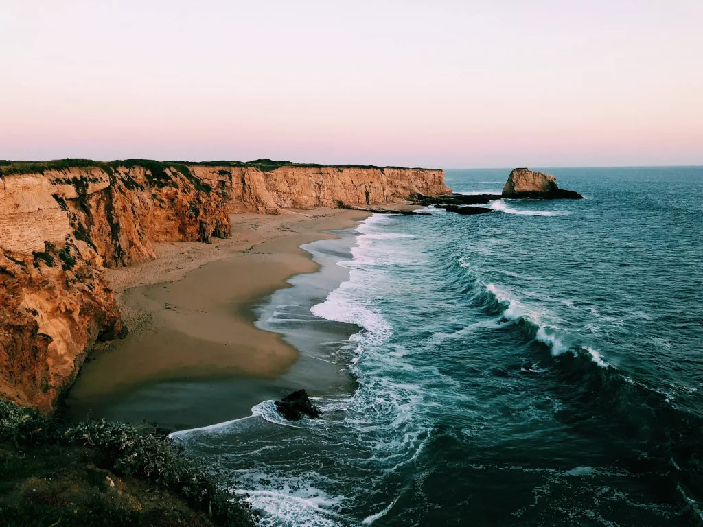 A beach with very high cliffs and rocks