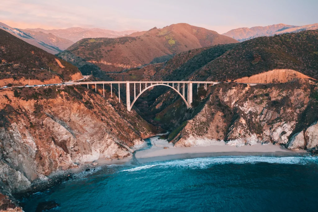 a bridge connecting two cliffs above a sea