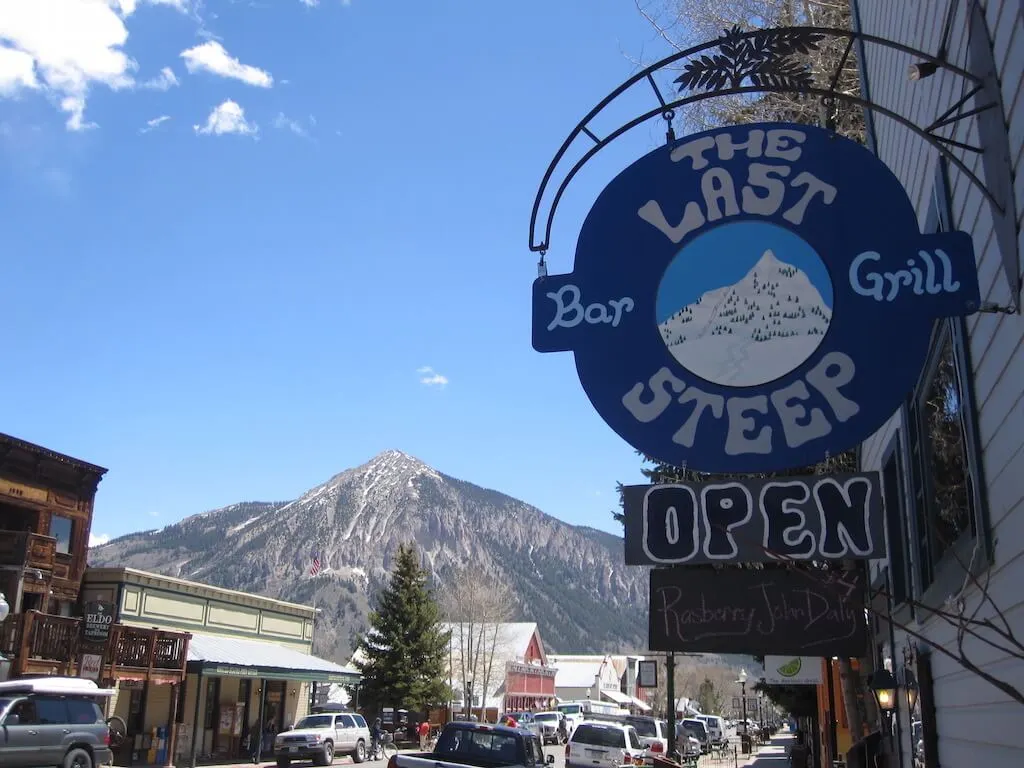 A sign of the last steep bar & grill which says open below