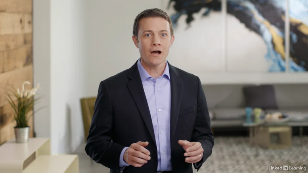 A mand in a suit and a purple shirt standing in a house