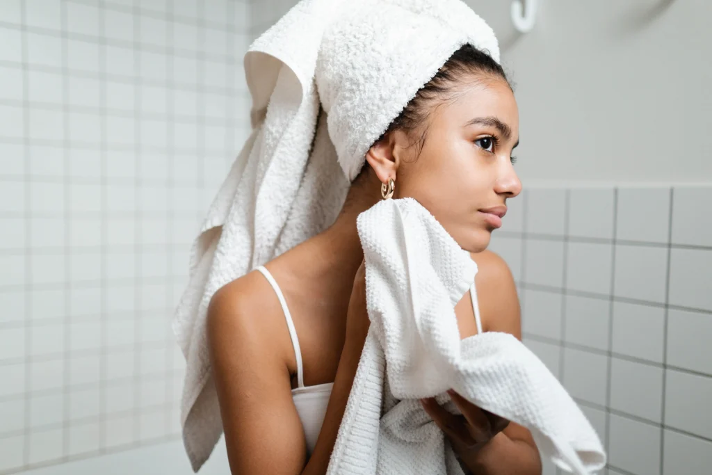 Girl cleans her skin in the morning, she is covered in towels.