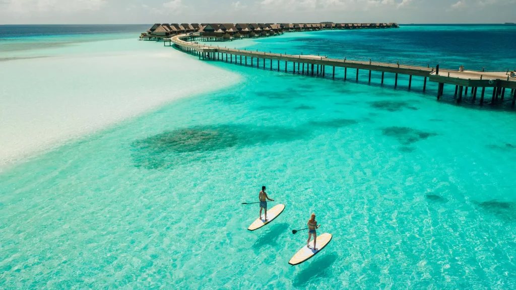 a guy and a girl on surf boards enjoying the sea