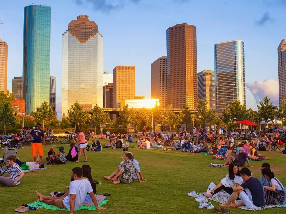 skyscrapers photographed from a park full of people in the time of a sunset