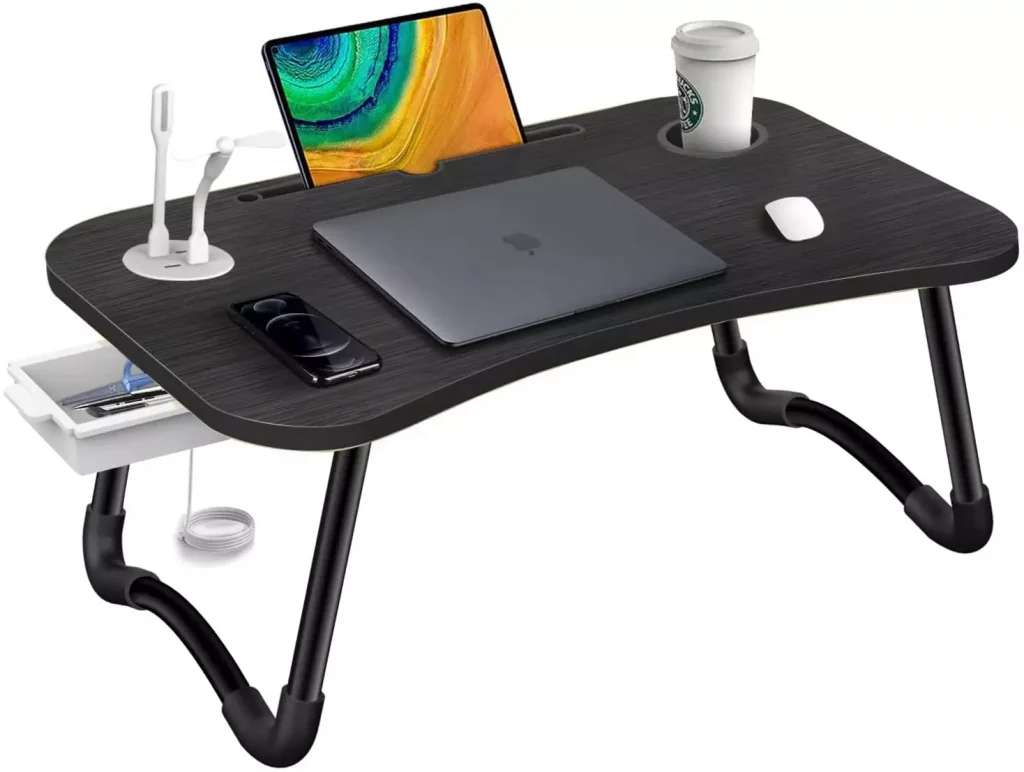 a desk with a laptop a tablet a mouse and a coffe mug on top of it