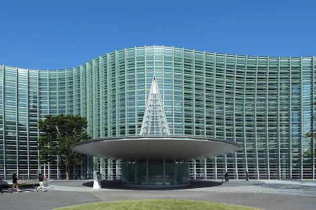 a full glass building infront of a fountain