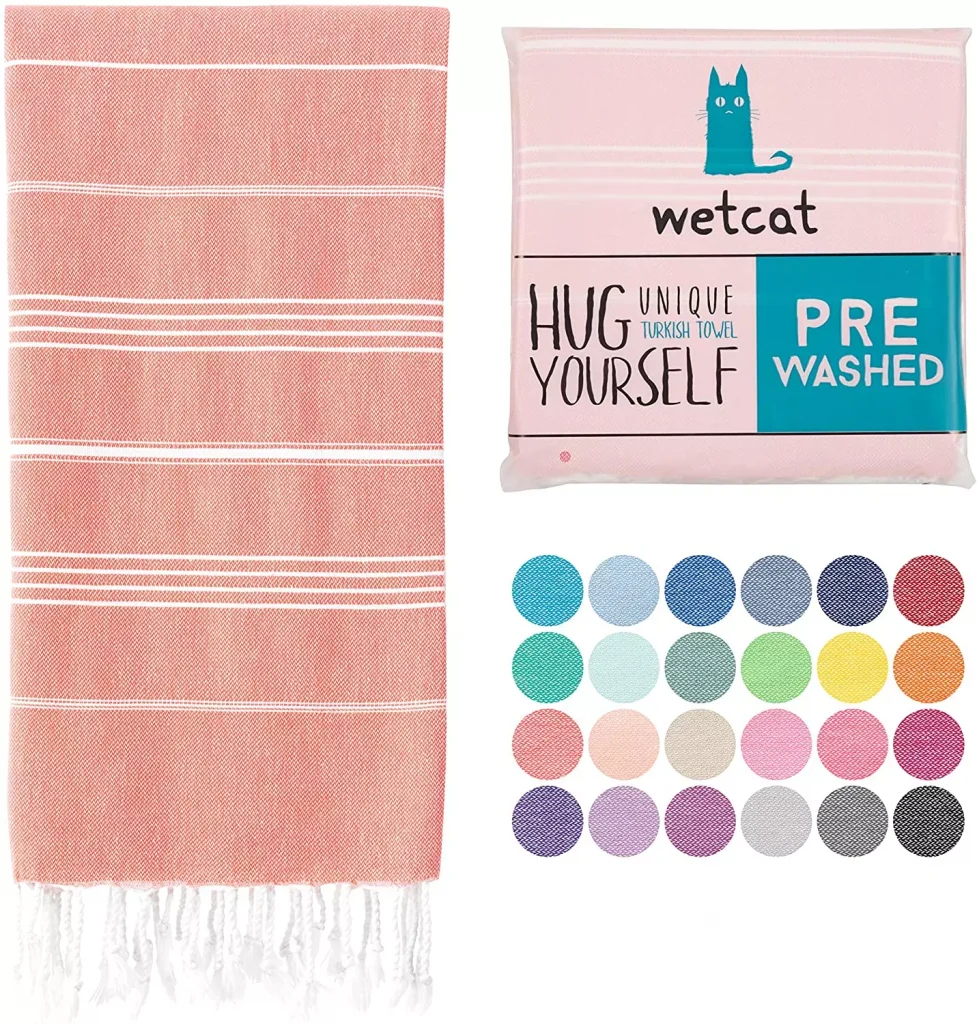 a pink color towel with white details for the beach