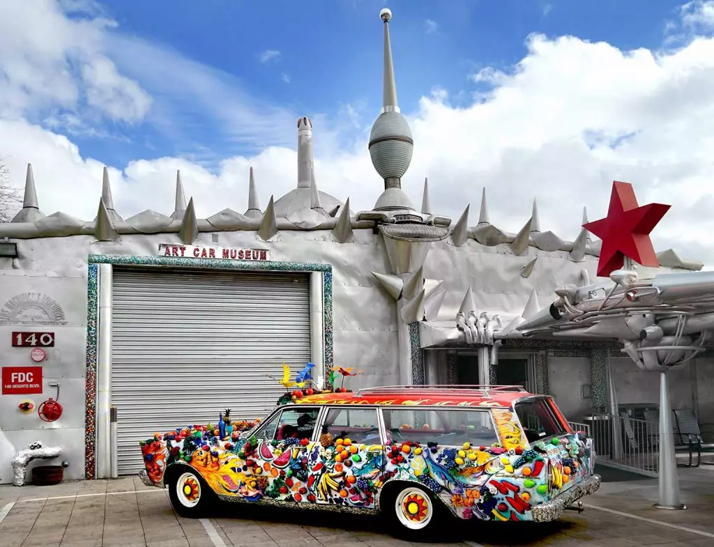 colorful car infront of a grey building 