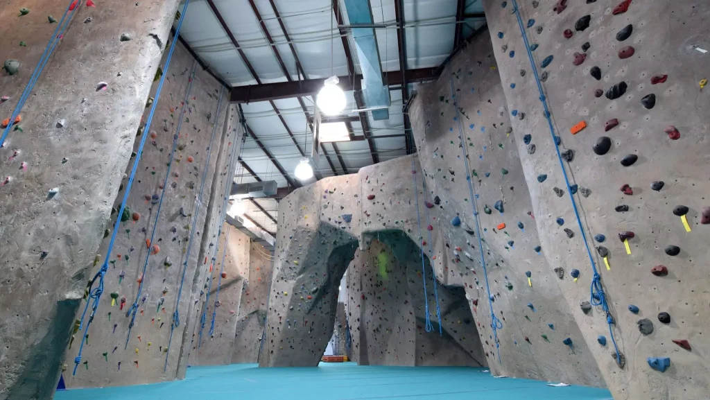 inside of a structure with grey walls and ropes infront of them