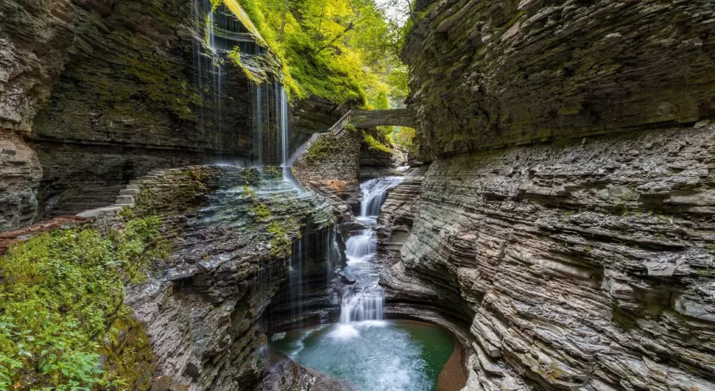 waterfall in the cliffs surrounded by green plants