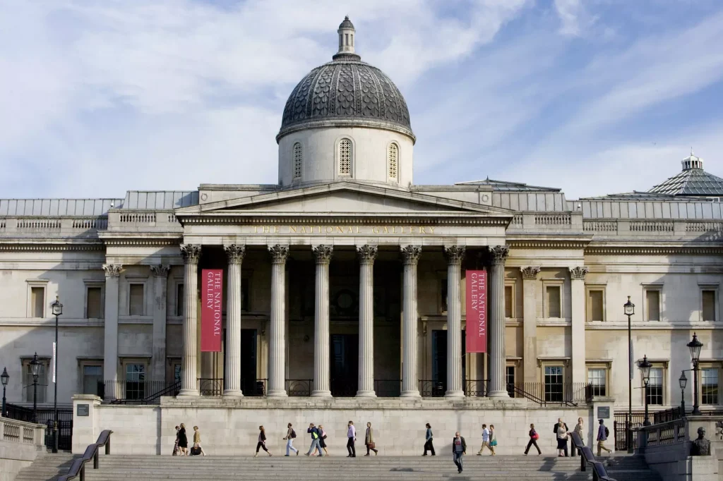 a big building with an acropolis on top of it and red flags next to it