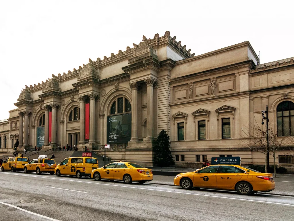 yellow cars in front of a stone building