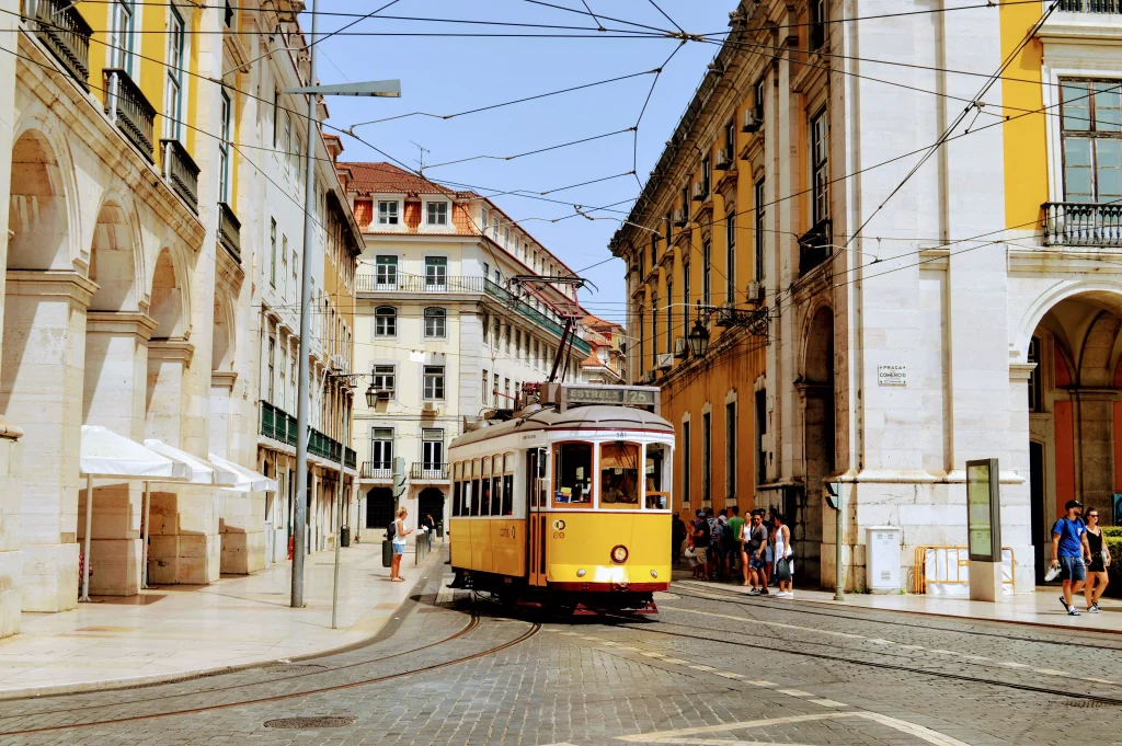 yellow train passing through a small street