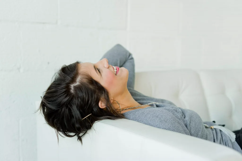 girl in a grey top laying on the bed