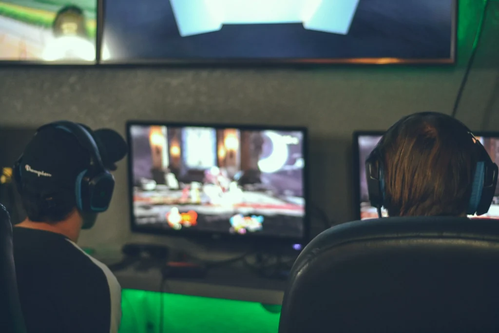 two guys with headphoens playing video games