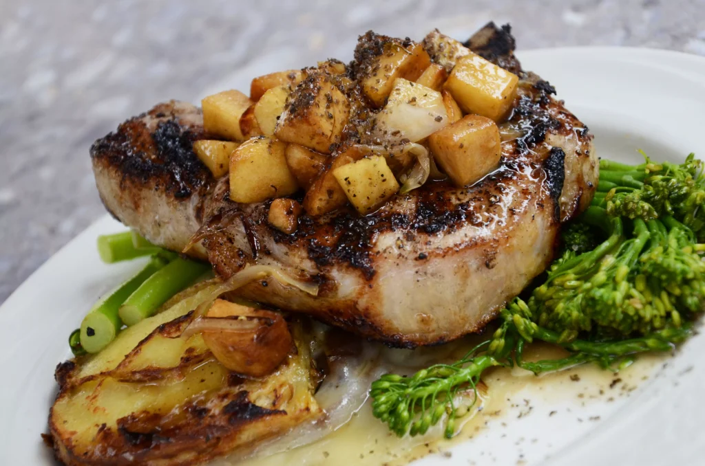 a stake with potatoes and green salad on a white plate