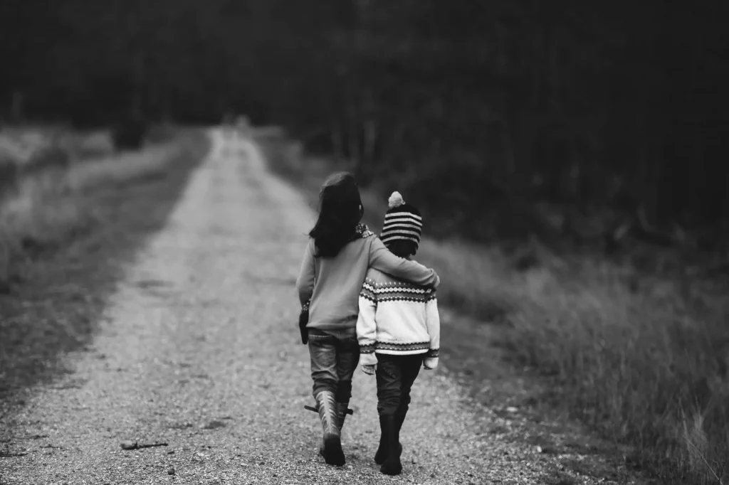 two people hugging each other on a country road