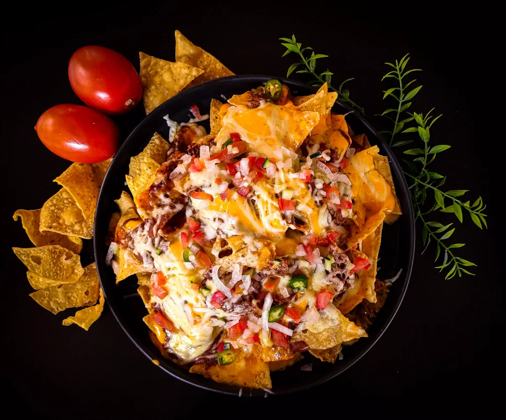 a bowl of nachos with tomatoes