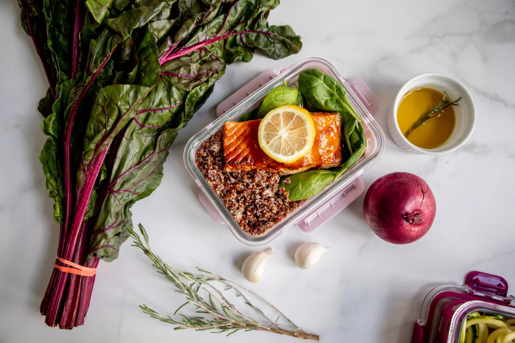 a bowl of vegetables next to fruits and plants