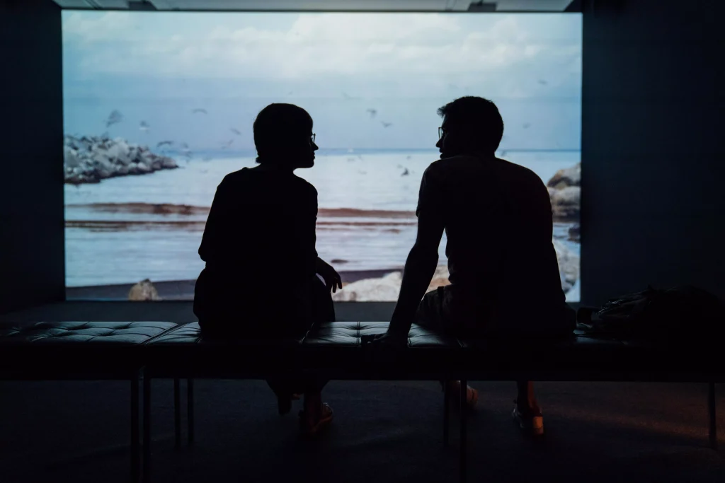 two people talking with each other in a museum