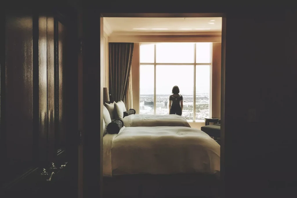 a person looking out of the window of a hotel room