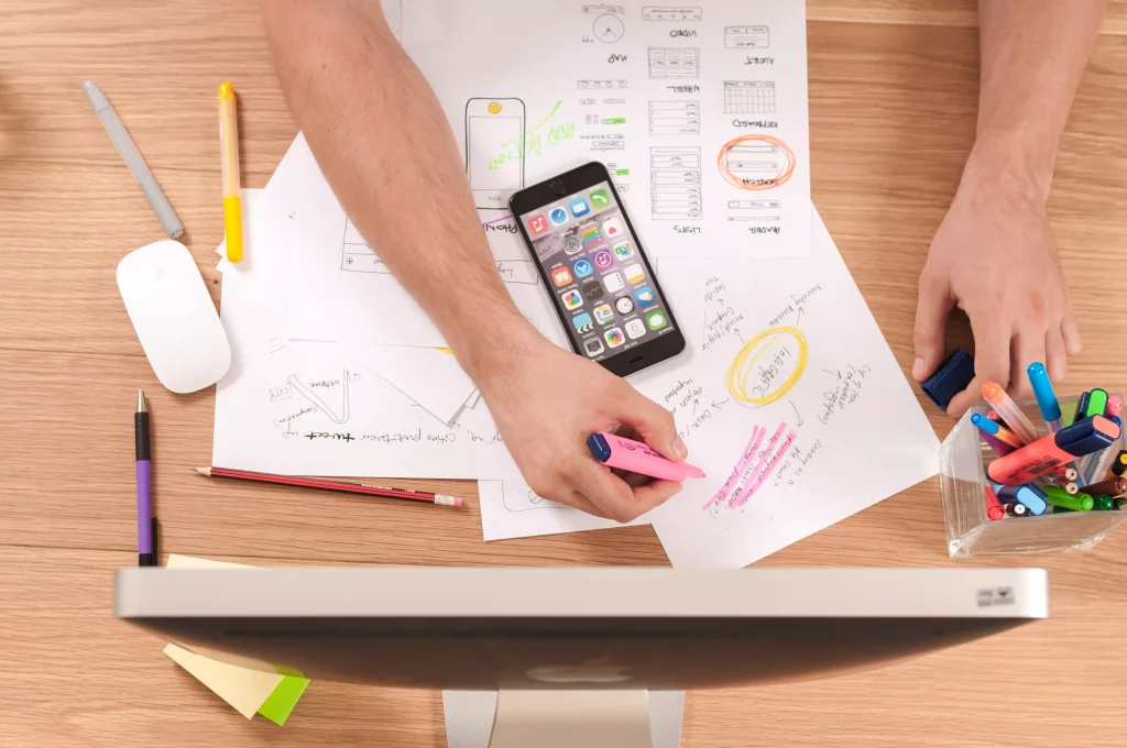 phones papers and a monitor on a office desk