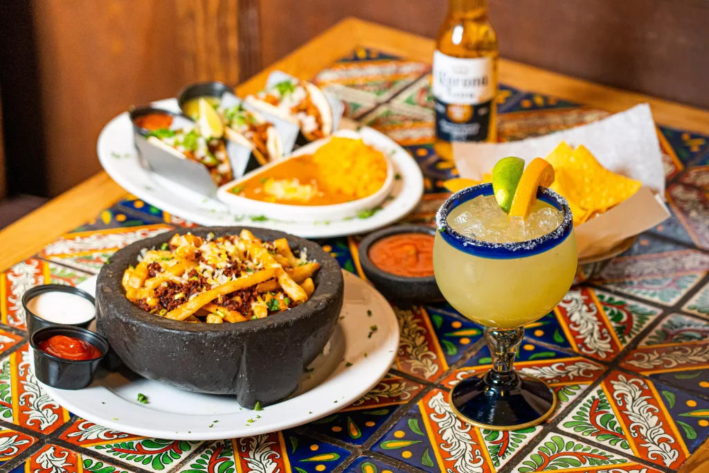 two white plates full of food next to a glass of lemon juice