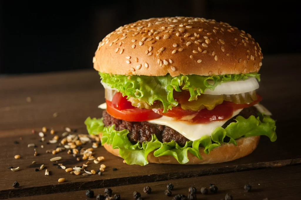 a hamburger with tomatoes and green letuce