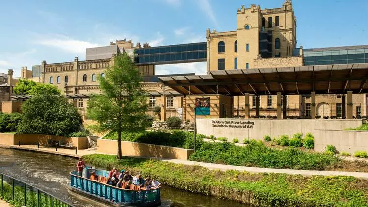 a building infront of a river with boats