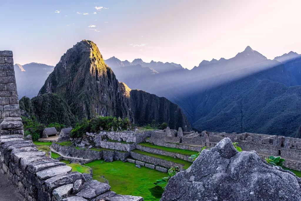 green fields and stone constructions on mountains photographed in the sunrise