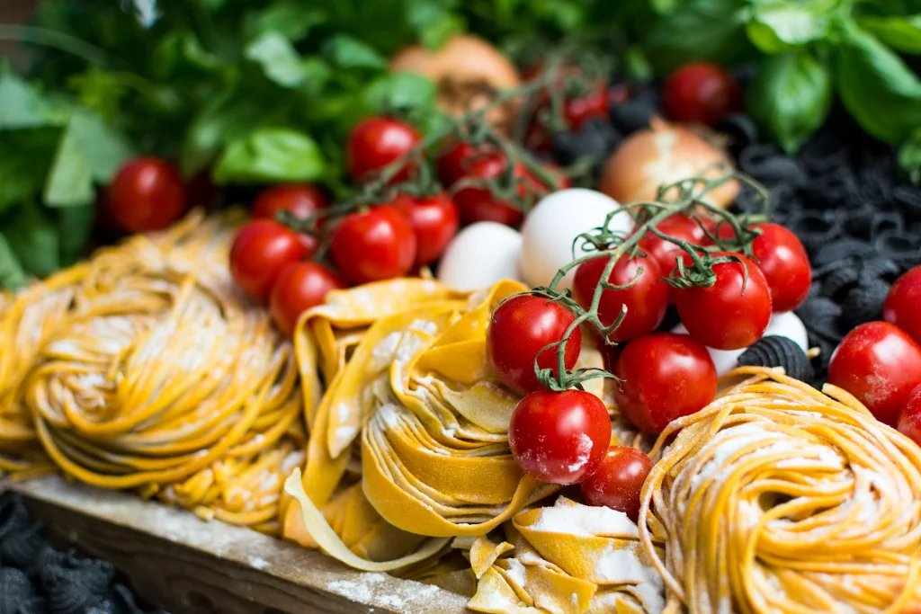 pasta and tomatoes below some green salad